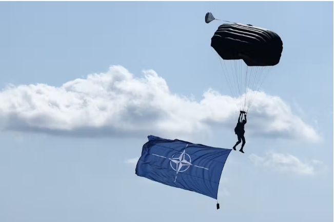 A paratrooper with a NATO flag performs during an air show in Radom, Poland, in August 2023. Jakub Porzycki/Anadolu Agency via Getty Images