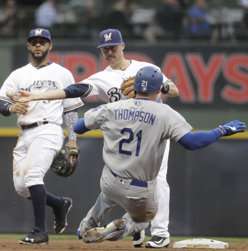 Milwaukee Brewers' Jake Elmore forces an out at second on Los Angeles Dodgers' Trayce Thompson as Elmore turns a double play on a ball hit by Yasmani Grandal during the fourth inning of a baseball game in Milwaukee. (AP Photo/Morry Gash)