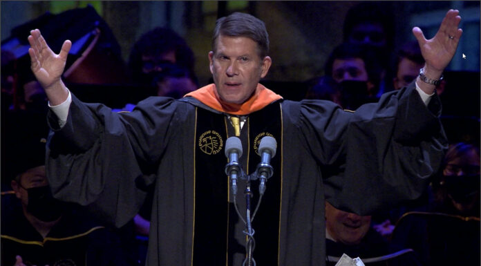 Krach Delivers Powerful Purdue Commencement Address with Proof of Equation: Transformation to the Power of Trust Keith Krach with his hands up at the Perdue Commencement