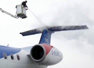A worker deices an airplane at the airport in Brussels. AP Photo/Virginia Mayo