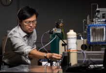 Prof. Jie Huang stands with the MOF-based breathalyzer his lab developed with support from the NIH. Michael Pierce/Missouri S&T