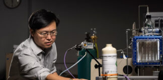 Prof. Jie Huang stands with the MOF-based breathalyzer his lab developed with support from the NIH. Michael Pierce/Missouri S&T