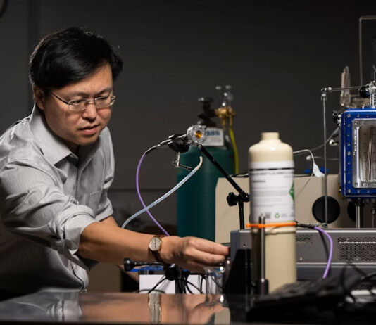 Prof. Jie Huang stands with the MOF-based breathalyzer his lab developed with support from the NIH. Michael Pierce/Missouri S&T